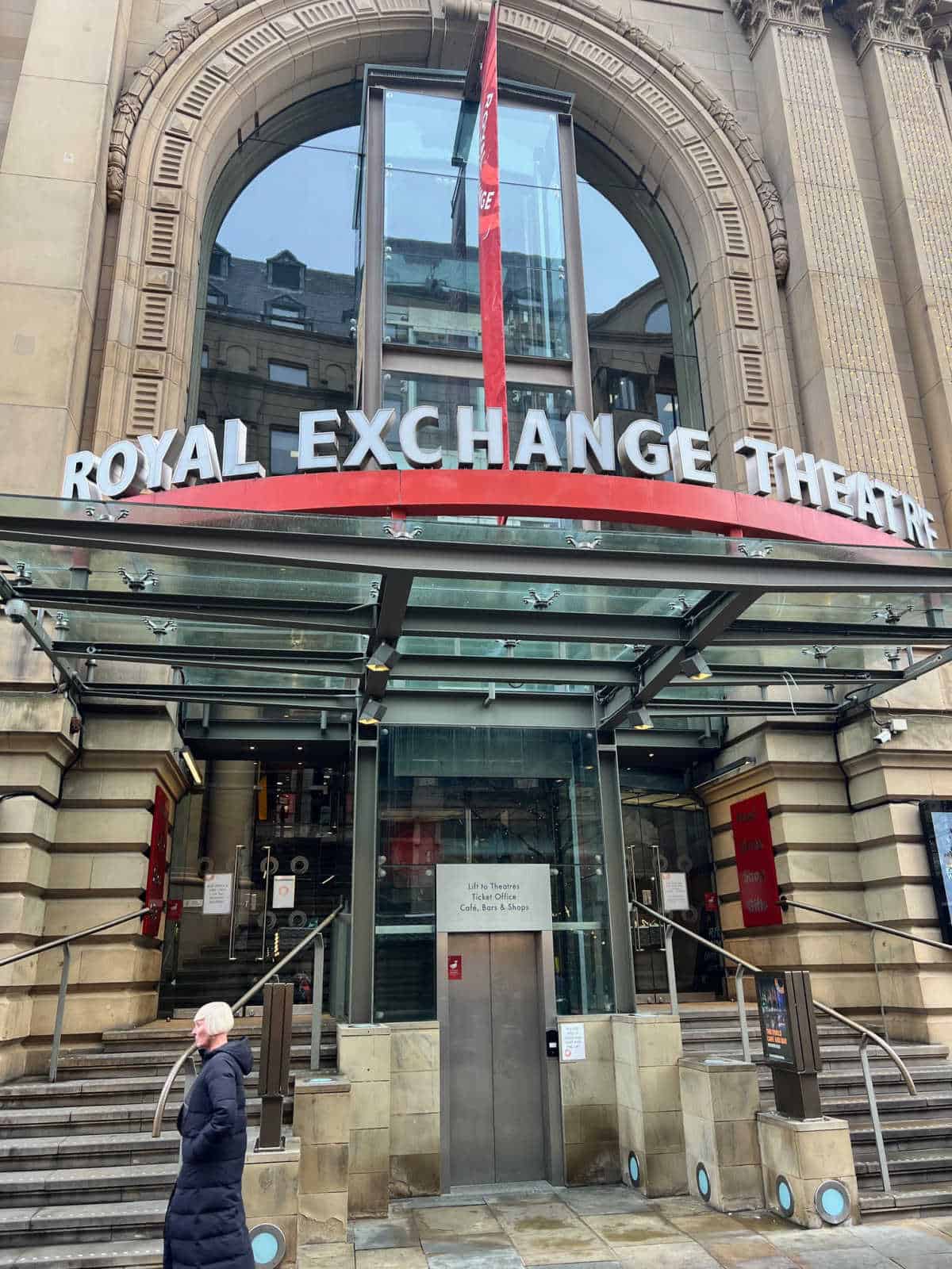 the outside of the Royal Exchange Theatre in Manchester city centre with a member of the public walking past