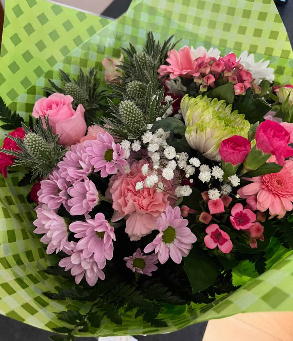 a selection of pink and white flowers for Mother's Day wrapped in green sellophane