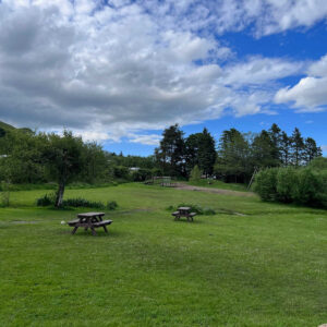 view from the top of the Quiet Site in Penrith, watermillock showing rolling hills and picnic benches with blue skies and the odd cloud